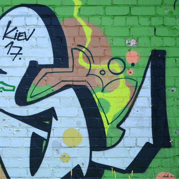 Fragment rysunki graffiti. Stary mur ozdobiony plamy farby w stylu kultury sztuki ulicy. Kolorowe tło tekstura w odcieniach zieleni. - Zdjęcie, obraz