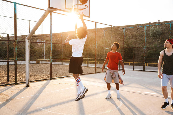 Group of young multiethnic men basketball players playing basketball at the sport ground - Fotoğraf, Görsel