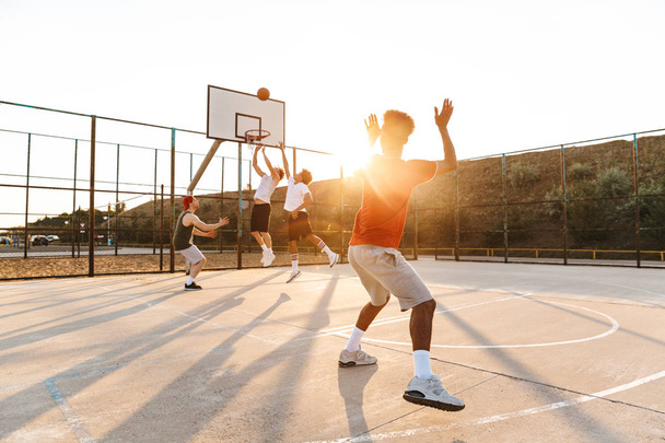 Group of young multiethnic men basketball players playing basketball at the sport ground - Fotografie, Obrázek