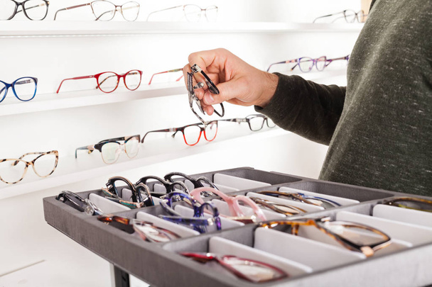 Fashionable corrective eye glasses on a shelf in optical store - Fotó, kép