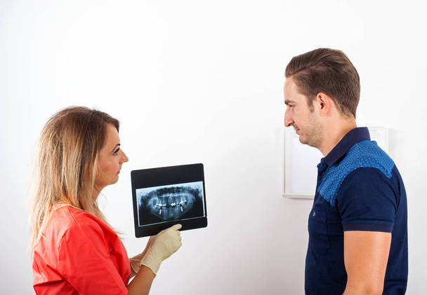 Dentist is showing to her patient an x-ray - Photo, Image