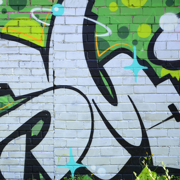 Fragment van graffiti tekeningen. De oude muur versierd met verf vlekken in de stijl van straatkunst cultuur. Gekleurde achtergrond textuur in groene tinten. - Foto, afbeelding