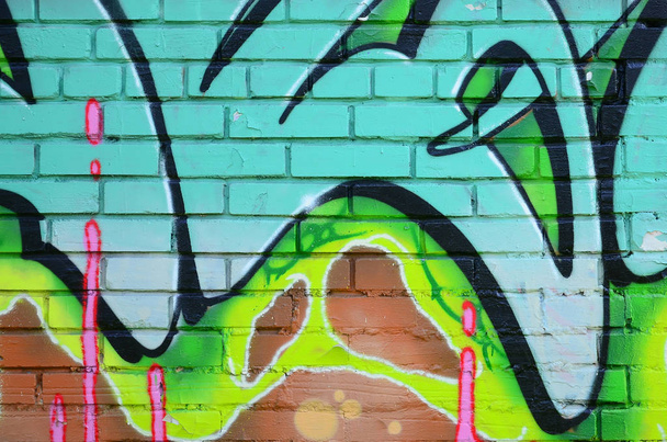 Фрагмент граффити рисунков. Старая стена декорирована краской в стиле уличного искусства. Цветная текстура фона в зеленых тонах
. - Фото, изображение