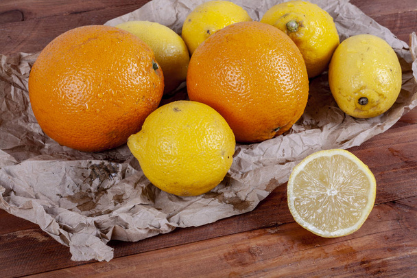 Багато лимонів і апельсинів на дерев'яному столі. Цитрусова тема
 - Фото, зображення