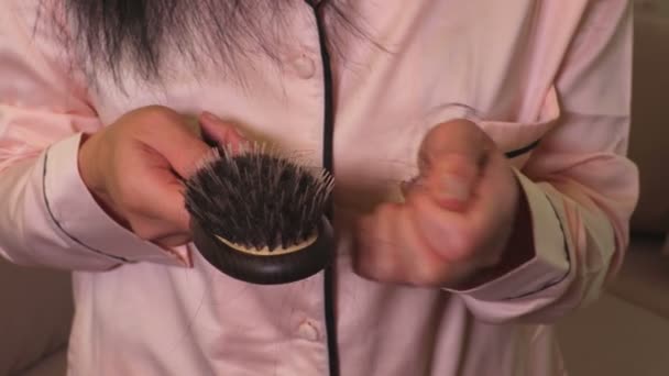 女性は櫛から髪を手で取る。毛損失の概念 - 映像、動画