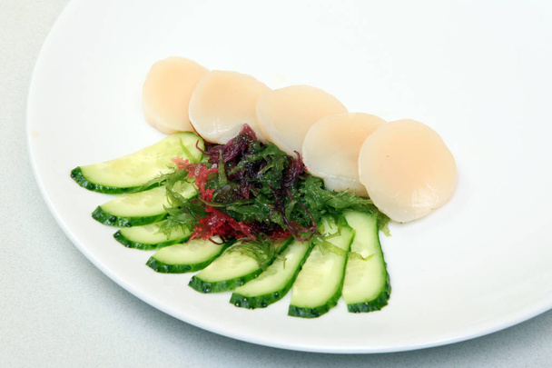 Sashimi.Tunse σε φέτες με φύκι και αγγούρι. Ιαπωνικά τροφίμων σε ένα όμορφο πιάτο. Διαιτητικά τρόφιμα. Μια εξαίσια ιαπωνικό πιάτο. - Φωτογραφία, εικόνα