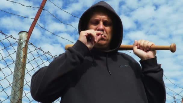 Άνθρωπος με ρόπαλο του μπέιζμπολ κοντά στο φράχτη από αγκαθωτό σύρμα - Πλάνα, βίντεο
