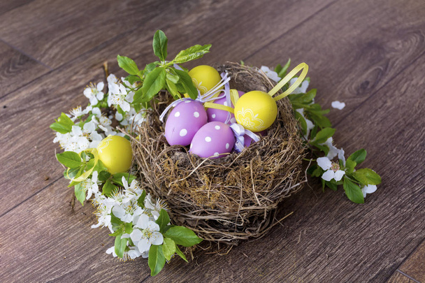 Easter Eggs  in Real Nest with Cherry Blossoms on a  Wooden Background. Easter Decoration  - Photo, Image