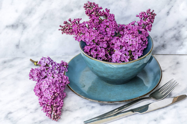Spring Table Setting with Vintage Blue Cutlery and Lilac Flowers on a Wooden Background.Floral Table Decor - Photo, Image