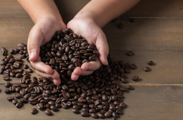 Fresh coffee beans in hands child, drink concept - Foto, imagen
