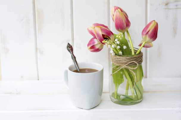 cup of coffee and bouquet of tulips on white wooden background - Photo, Image