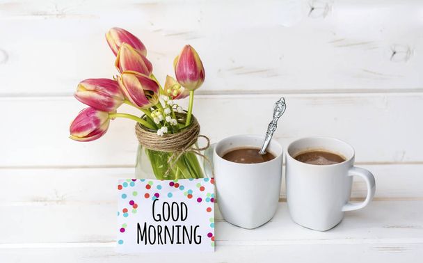 cups of aromatic coffee with tulips flowers and good morning  message  - Foto, Bild