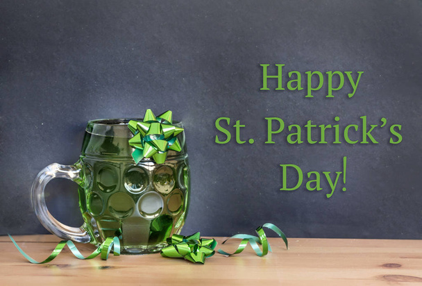 Green Beer with Green Ribbon for Saint Patrick's Day on a Black Board Background - Photo, image