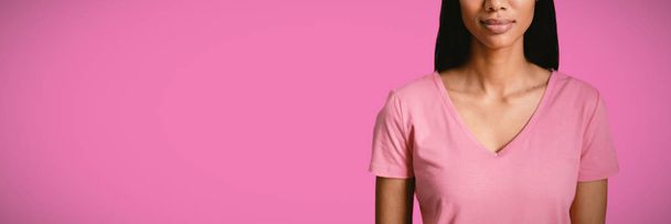 woman in pink shirt standing against pink background - Фото, изображение