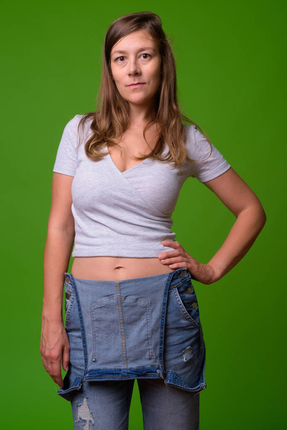 junge schöne Frau vor grünem Hintergrund - Foto, Bild