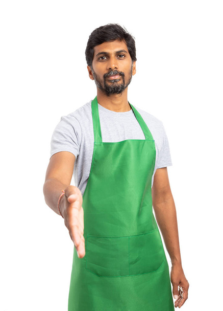 Indiase winkel manager of supermarkt medewerker aanbieden van handdruk als partnerschap concept geïsoleerd op witte studio achtergrond - Foto, afbeelding