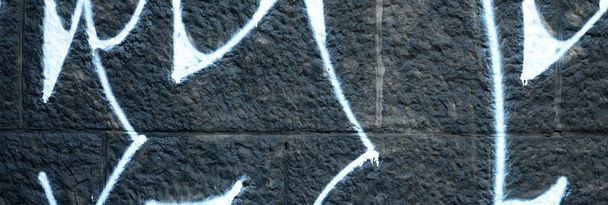 Fragment of graffiti drawings. The old wall decorated with paint stains in the style of street art culture. Colored background texture. - Фото, изображение