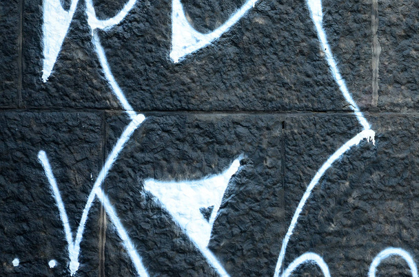 Fragment van graffiti tekeningen. De oude muur versierd met verf vlekken in de stijl van straatkunst cultuur. Gekleurde achtergrond textuur. - Foto, afbeelding