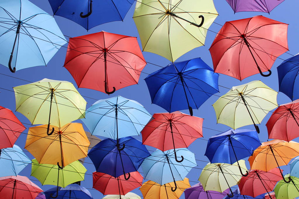 Πολύχρωμες ομπρέλες που φέρουν στο μπλε του ουρανού. Το καλοκαίρι - Φωτογραφία, εικόνα