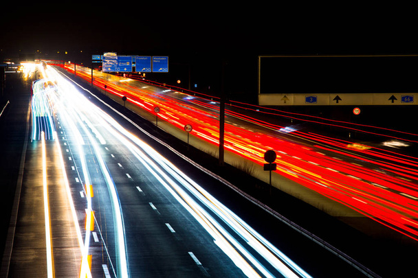 Night traffic trails on a german highway, motion blur, with trucks, cars and busses, in Germany, A3, Wiesbadener Kreuz - 写真・画像