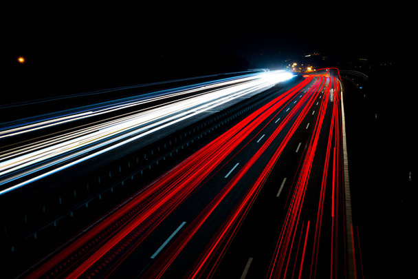 Nachtverkehrsspuren auf deutschen Autobahnen, Bewegungsunschärfe, mit Lastwagen, Autos und Bussen, in Deutschland, Autobahn 3 - Foto, Bild