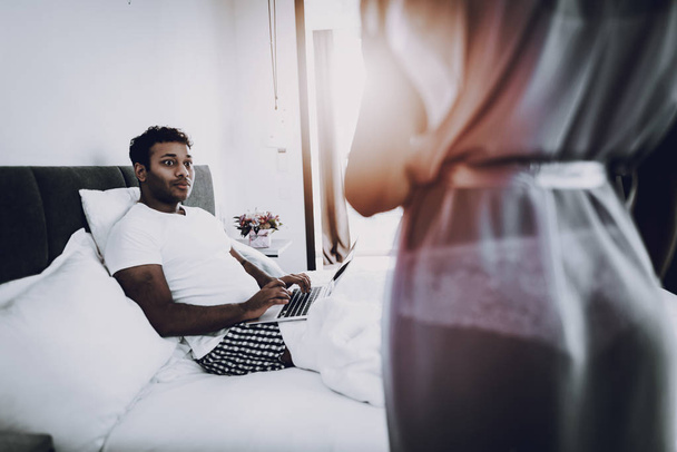 Girl Is Flirting With Boyfriend. Bedroom Concept. Afro American Couple. Home Leisure. Sexy Body. Healthy Lifestyle. Weekend Activity. Need For Attention. Night Blouse. Happy Sweathearts. - Foto, afbeelding