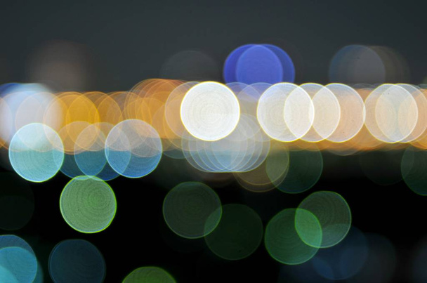 abstrakter Hintergrund aus bunten defokussierten Bokeh-Lichtern im verschwommenen Nachthintergrund - Foto, Bild