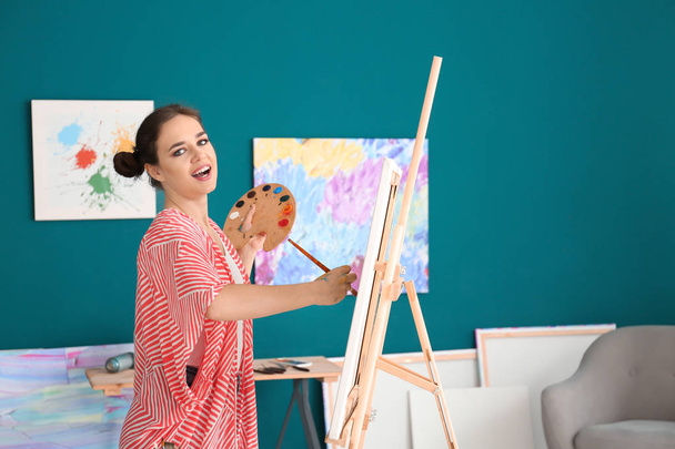 Γυναίκα καλλιτέχνης ζωγραφική εικόνα στο εργαστήριο - Φωτογραφία, εικόνα