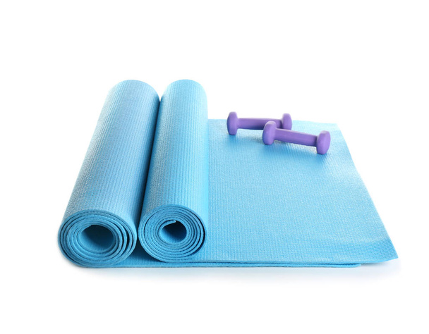 Yoga matten met halters op witte achtergrond - Foto, afbeelding