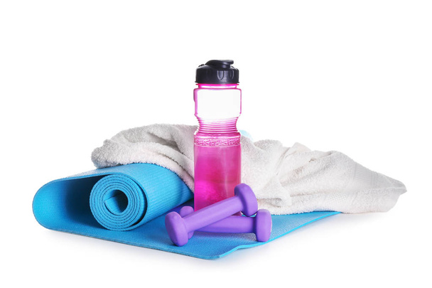 Циновка для йоги с бутылкой воды, гантели и полотенце на белом фоне
 - Фото, изображение