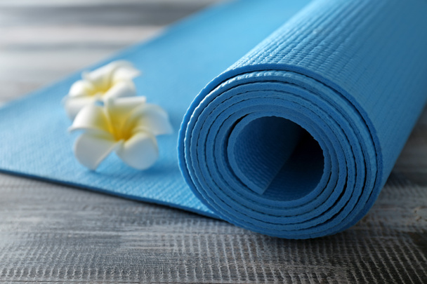 Color yoga mat and flowers on wooden background - Φωτογραφία, εικόνα