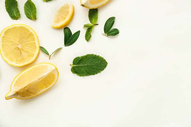 Fresh lemons and green leaves on white background, flat lay - Photo, Image