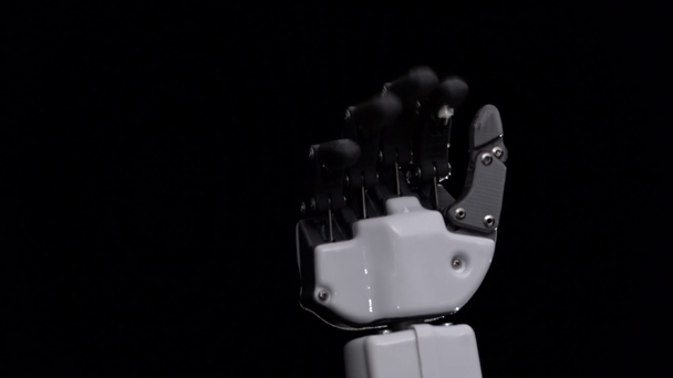 Hand eines Roboters aus nächster Nähe winkt zum Abschied. schwarzer Hintergrund. Nahaufnahme - Filmmaterial, Video