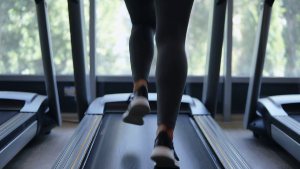 Fitness dívka běží rychle na trať robota ve fitness klubu, Blondýnka ve sportovní oblečení cvičit. Koncept zdravého životního stylu, sportovní aktivity - Záběry, video