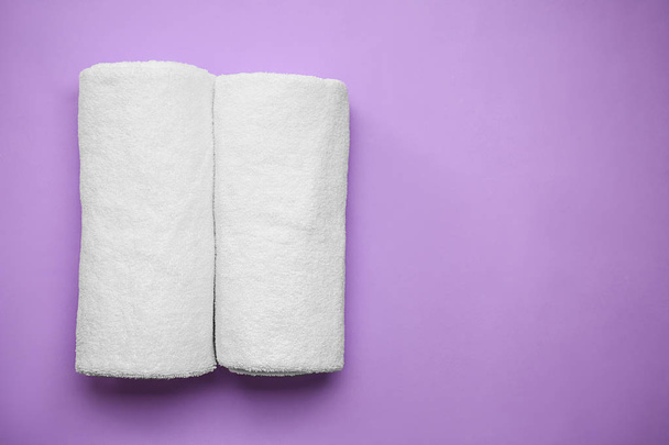 Rolled clean soft towels on color background - Photo, Image
