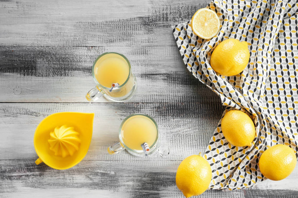 Flat lay composition with fresh lemon juice on wooden table - Photo, Image