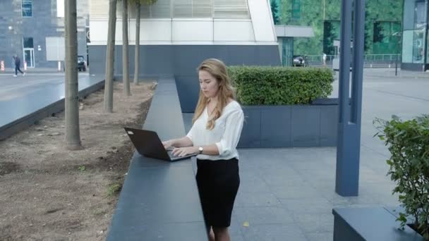Young businesswoman working on laptop in city park business center - Footage, Video