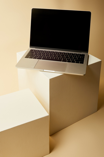 primo piano del computer portatile con schermo bianco su cubi beige
 - Foto, immagini