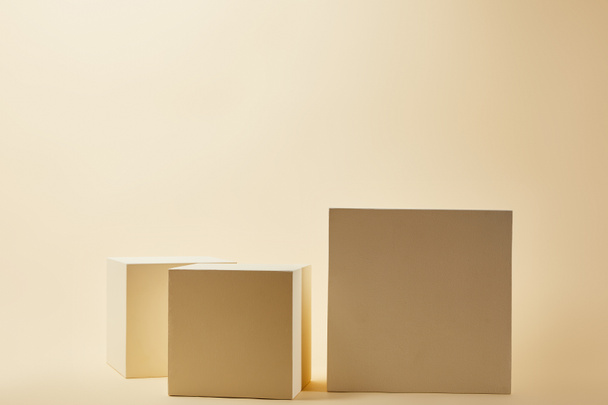 still life of cubes in various sizes on beige surface - Photo, Image