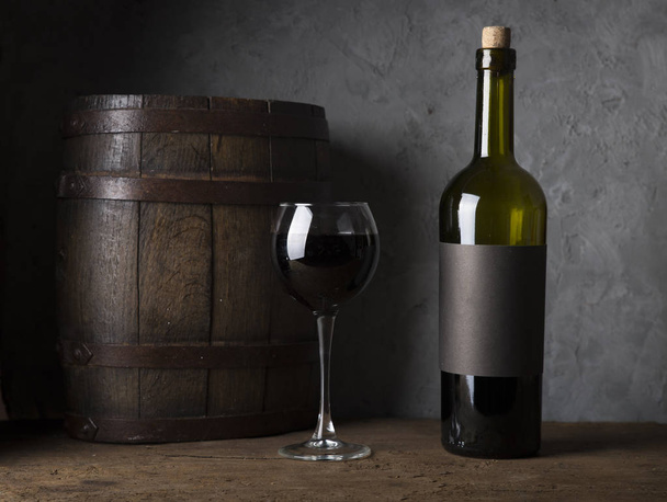 exzellente Rotweinflaschen, Weinglas, Fass und Korkenzieher auf rustikalem Holztisch: traditionelles Konzept der Weinbereitung und Weinverkostung - Foto, Bild
