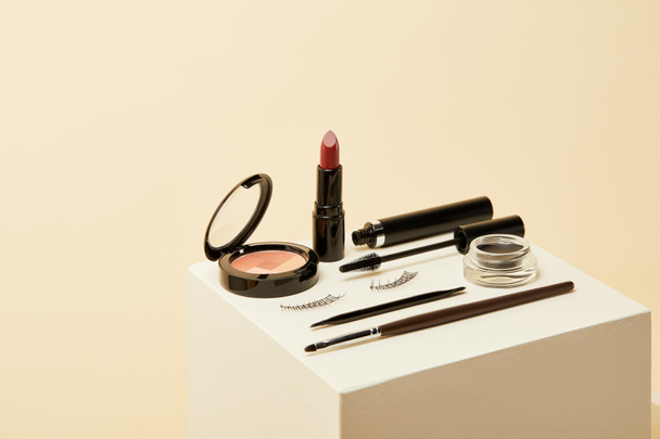 close-up shot of makeup supplies kit on beige cube - Photo, Image