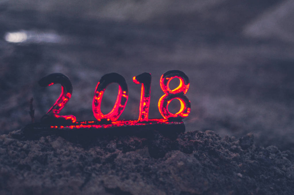 Деревянные фигуры 2018 года сжигаются в пламени. Концептуальное фото конца года
. - Фото, изображение