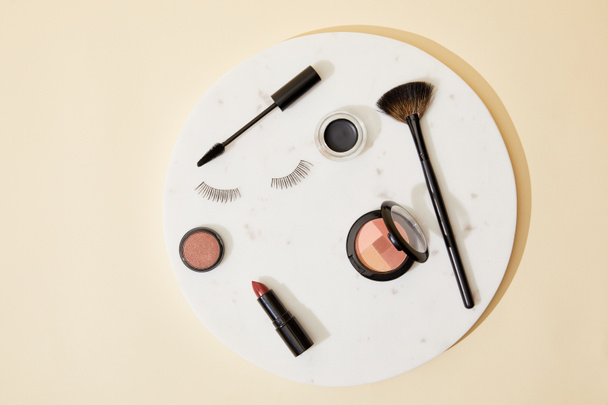 top view of various cosmetics lying on round plate - Photo, Image