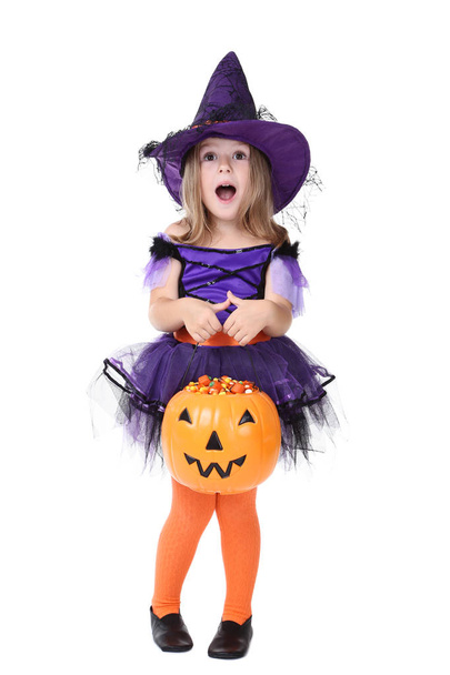 Young girl in halloween costume with pumpkin bucket on white background - Φωτογραφία, εικόνα