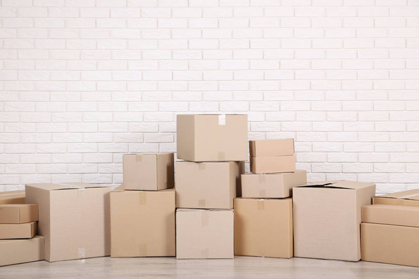 stacked cardboard boxes on brick wall background - Foto, afbeelding