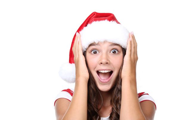 Emotional girl in santa hat with mouth open on white background - Foto, Imagen