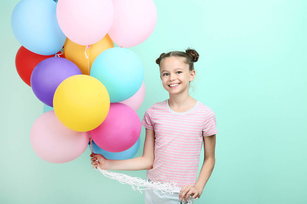Beautiful young girl with colored balloons on mint background - Фото, зображення