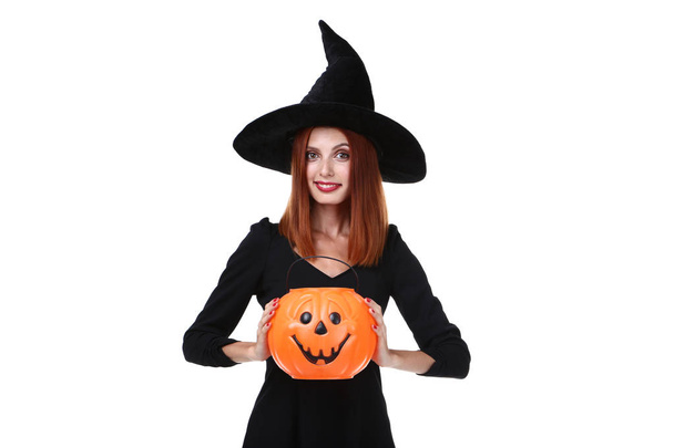 redhaired woman in halloween costume holding pumpkin bucket on white background - Photo, Image