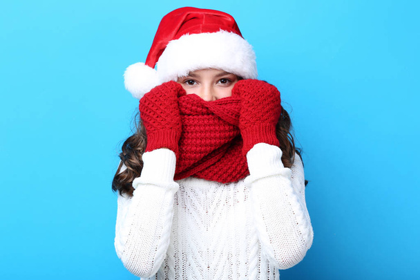 teenage girl in santa hat, gloves and scarf on blue background - Foto, Imagem