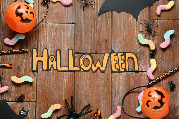 Inscription Halloween with decorations and candies on wooden table - Foto, Imagem